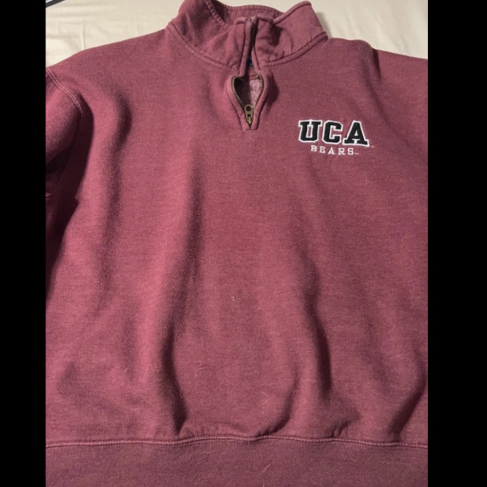 it is burgundy/magenta and it’s a college crew neck zipper